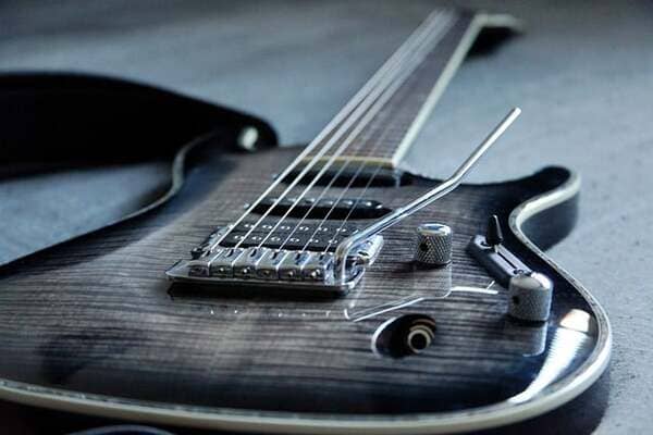 Eine E-Gitarre für Einsteiger liegt auf einem weißen Holzboden.