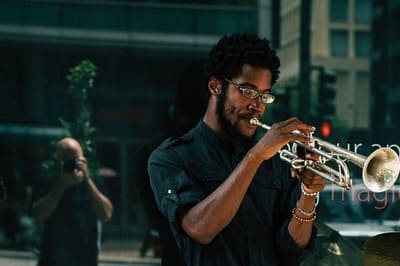 Ein afroamerikanischer Mann spielt Trompete.
